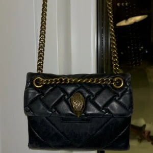 Kurt Geiger  - Säljer min Kurt Geiger väska i svart och guld för 1000 kr, original priset är 3276 kr. 💗 Den är lite sliten och har ett litet hål i vänstra hörnet men inget som jag tänker på. 💗 Köparen står för frakten! Jag kan mötas upp. 💗