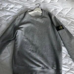 Stone island tröja - Säljer min stone island tröja då jag ej använder den längre. Litet hål i höger armbåge son syns på sista bilden. Går enkelt att laga men inget jag vill lägga tid på. Såklart äkta ock qr kod kan skickas privat