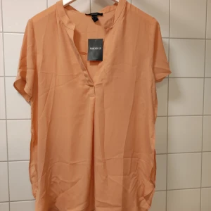 Blus - Tunn blus med sprunn. Oanvänd 