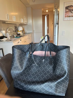 By Malene Birger - Tote bag Abigail - Tote bag Abigail i färgen carcoal. Stor och rymlig vardagsväska! Man får ner en laptop exempelvis om det behövs. Den är väl använd och remmarna har blivit väldigt slitna och även kanterna på väskans undersida. Handtagen går att laga hos skomakare  