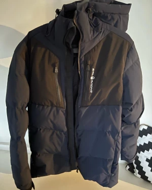 Vinterjacka SAIL RACING Patrol Down Jacket - Blå - Detta är en vinterjacka jag har bestämt mig för att sälja pga jag inte gillar jackan längre men det är en jätte fin jacka som värmer en jätte bra och som sitter perfekt. Inga defekter på jackan, jackan är så gott som ny. KVITTOT INGÅR!! 