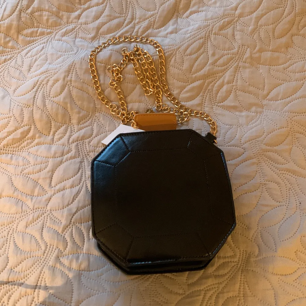 En parfym liknande väska med guld kedja som aldrig är använd!. Väskor.