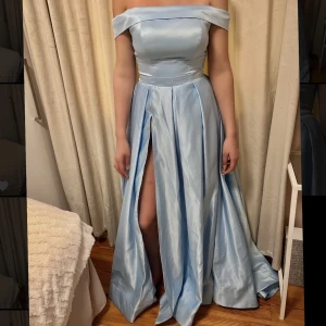 Blå balklänning  - Säljer nu min super snygga ljusblåa balklänning som är helt oanvänd, sitter som en strl Medium och är super bekväm😍 säljer för 1400kr nypris 2000kr.  Mått: Midja 74cm, längd (från nyckelben till mark) 150cm, byst 106cm, höft 108cm. (INGA DEFEKTER!)