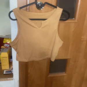 Brunt croppat linne - Helt nytt brunt croppat linne med en liten ”slits”. I nyskick.