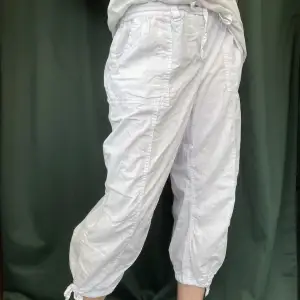 Sköna vita tygbyxor perfekta till sommaren. Tunt tyg och fyra rymliga fickor. Knytbar i midjan så man kan välja om man vill bära dem låg eller högmidjat. Lite croppade så de tar slut på vaden. Skriv för fler bilder eller specifikation om storlek:)