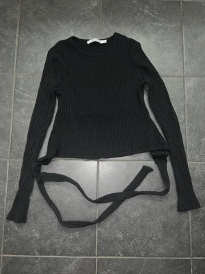 Svart topp med öppen rygg - Säljer en svart topp med öppen rygg från NA-KD i storlek xs, pris 150kr