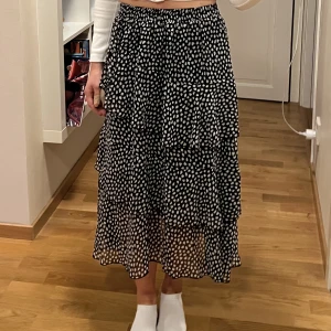 Lång kjol  - Superfin lång kjol från shein med volanger. Svart med vita prockar, resår i midjan! Jag är 161 cm lång! Storlek S/XS *Frakt 54kr, spårbart paket med PostNord!