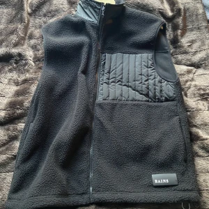 Fleeceväst - En snygg fleeceväst från Rains köpt på Junkyard, den är väldigt sparsamt använd och i väldigt gott skick. 