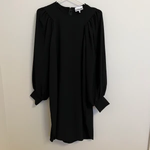 Ganni klänning - Superfin klänning från GANNI. Som ny, endast använd 1 gång. Jag är 173 cm och den slutar drygt 1 dm ovanför knäna på mig. Den har långa puffärmar. Fin och diskret dragkedja vid nacken. 