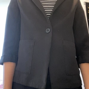 Svart kavaj - Den är i väldigt bra sick efter den inte har kommit till användning, vilket jag ångrar för att den har blivit för liten. Den har inte används många gånger.Plagget har två fickor på fram sidan samt en svart knapp.