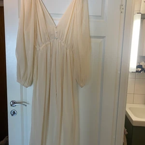 Klänning  - Aldrig använd. Ljusgul men mer beige i mitt tycke. 