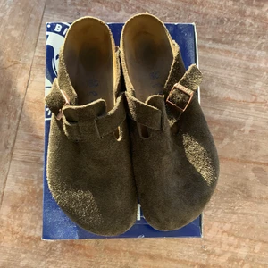 Birkenstock Boston-tofflor - Riktigt riktigt tjusiga tofflor. Säljer ENDAST pga fel storlek. Fin mjuk mocka och väldigt bekväma. Använda inomhus kanske 5 gånger, har fortfarande den där nya skor-doften. OBS nypris är 1600kr så detta är enligt mig ett förbaskat bra erbjudande.
