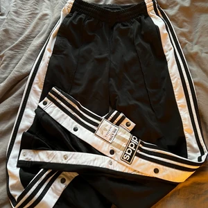 Adidas byxor  - Snygga Adidasbyxor i storlek 38 Min dumhund har bitit på ena knappen på byxan! Så går inte knäppa just den. Men ingenting man ser tydligt!🥰