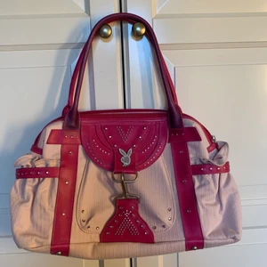 Playboy - Sjukt cool Playboy väska som är ljusrosa. Säljer då den inte kommer till användning längre. Några jättesmå fläckar på baksidan av väskan men inget man tänker på. Den ser smutsig ut på bilderna pga ljuset men kan ta bilder i dagsljus vid intresse. 200kr plus frakt💕💕💖