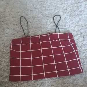Topp - Är en röd topp med vita linjer. Passar bra till vita byxor eller shorts. Storlek S