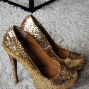 STRIPPER SHOES - Guldiga skyhöga klackar täckta i glitter. Aldrig använda endast testade. För höga för mig haha.