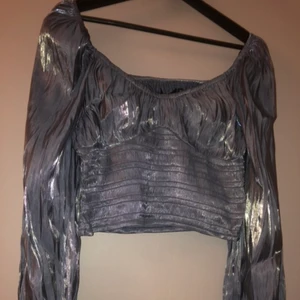 Blå topp - Blå skimrande topp med ballong ärmar