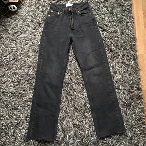 Raka jeans från NAKD - Svarta raka jeans med slitningar längst ner på benen, storlek 32. Går just över fotknölarna och jag är 166cm. Iprincip helt nya använda få ggr. Köparen står för fraktkostnad. 