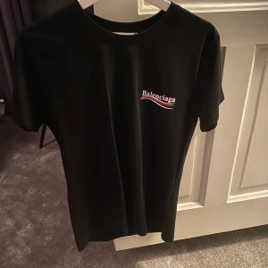 T-shirt med logga - Svart T-shirt strl 34/36 med tryck på bröstet och bak på ryggen i fint skick 