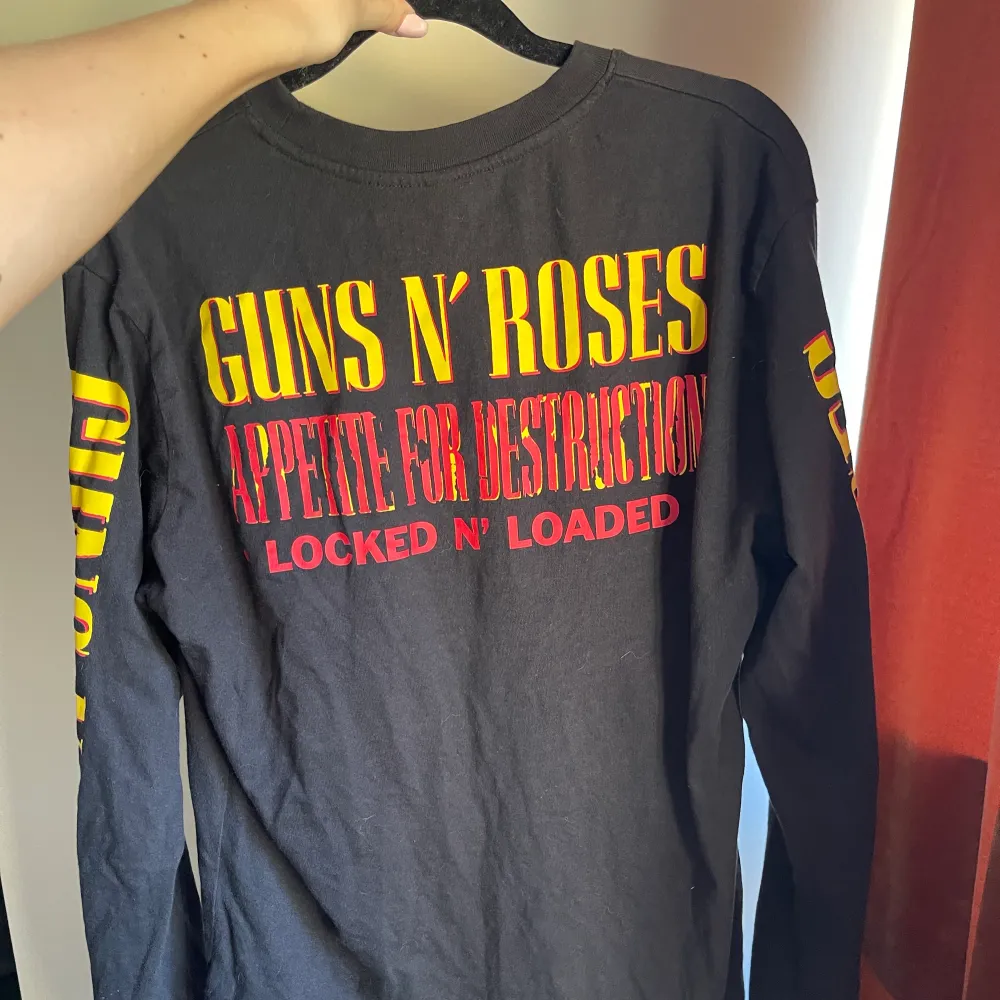 Tröja från H&M med Guns N’ Roses tryck i fram, i bak och på ärmarna. Ganska lång, men jag brukar vika in den i byxorna. Från herravdelningen ifall det skulle spela roll. Tröjor & Koftor.