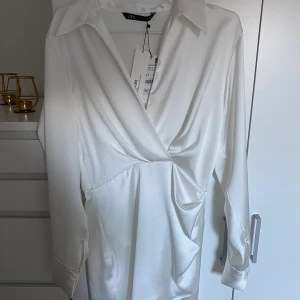 Vit klänning - Säljer denna vita jättefina klänning från Zara då jag tyvärr inte fått någon användning för den. Den är helt ny med lappar kvar. Slutsåld på Zaras hemsida. Skriv för bilder hur den ser ut på! 😍