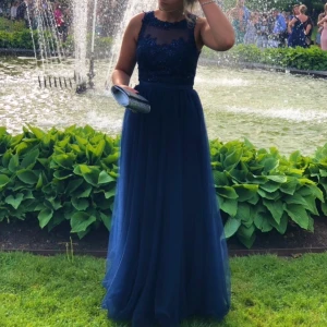 Balklänning - Jättefin balklänning i mörkblå. Pärlor och glitter på överdelen samt att den är vadderad. Använd en gång så mycket bra skick! Köparen betalar frakten 66kr annars möts jag gärna upp