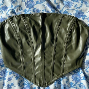 Bandeau topp - grön - Jättefin och helt ny bandeu topp av skinn. Helt oanvänd och säljs i både svart och grön.💚🖤 (Båda oanvända). Anledningen till att jag säljer de e för att de var lite stora i bysten på mig (har storlek 65A) har du större byst.. köp gärna! ❤️