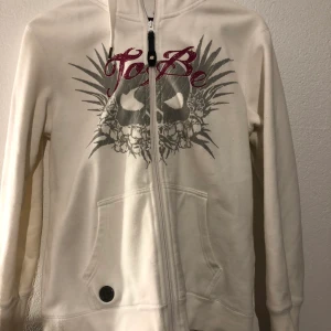 Tröja med dragkedja - Tröja i använt skick, trycket är slitet men tröjan är det inga fläckar på eller liknande. Fler bilder kan fås