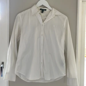 Ralph lauren skjrota S  - Äkta ralph lauren skjorta storlek S, har en pytte liten fläck på höger sida som knappt syns. Ser ut som damm från avstånd. Annars i skick som ny. 