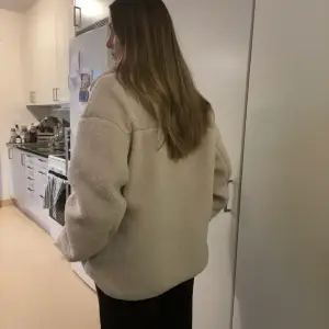 Cream white teddy Jacket from H&M in a size Small. It’s oversized, I’m a size 38/40 and it fits me.  Has som darker colouring on the bottom inside from wearing dark trousers with it. I have not tried to wash it off, it doesn’t show on the outside. 