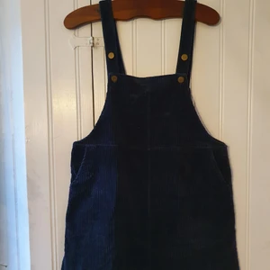 Manchester hängsel-kjol Marinblå Storlek M - Hängsel-kjol i marinblått manchester tyg. Gullig design med stiliga bronsknappar. Har fickor! 