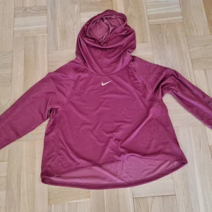 Nike running tröja 2x plus size - Träningströja från Nike running. Fotona ger missvisande färg. Den är inte röd utan den är terrakotta/brons. Strl 2x, dvs 54/56. Skorstenskrage/huva. Mycket fint skick.  Mått ärmhåla -> ärmhåla: ca 70 cm × 2.  Ärmhåla -> längst ner på tröjan: ca 33 cm.