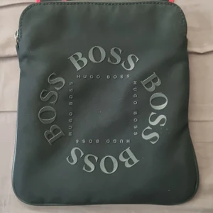 Hugo boss axelväska - Det är en röd/svart hugo boss axelväska svår och få tag på och den är i bra skick köpte den i sommras men använder tyvärr inte den längre lika mycke som jag hade hoppats