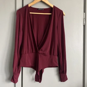 Body  - Vinröd body med öppna ärmar. Stl M