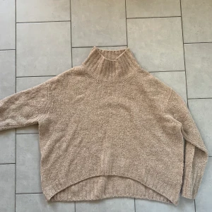 Stickad H&M tröja storlek M - En skön och mysig beige stickad tröja som passar till allt! Armarna är lite längre, en kort polo i halsen och tröjan är lite längre baktill och kortare framtill. Den är ca 4 år gammal men är fortfarande en skön tröja! 