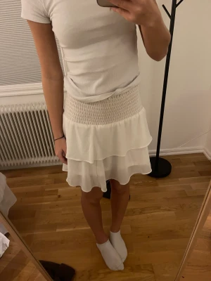 Kjol vit  - En vit kjol från Chelsea. Vet inte om säljs frf. Volangkjol. Går att använda som topp. 
