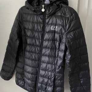Armani jacka  - Helt ny oanvänd äkta Armani jacka med avtagnimgsbar luva. Svart och den är storlek xs/ s. Man får med lilla Armani påsen till den också. 