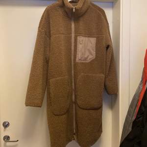 Brun teddyjacka från H&M, produktnummer 0991731 Längd: 106cm Ärm: 52,4cm Axel: 64cm