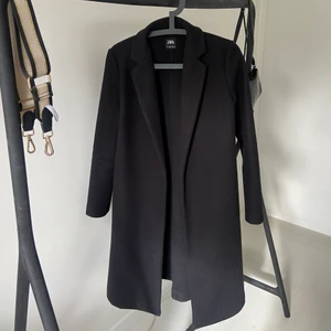 Svart kappa zara - Jätte fin kappa från zara med fickor på båda sidor. Super snygg och går ner till knäna på mig som är 170. Säljer för jag har hittat en ny kappa. Skriv för fler bilder!💗 Vid snap affär kan jag sälja den för 200kr