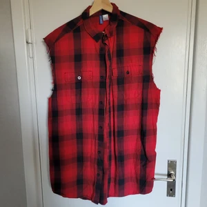 H&M Divided rutig väst skjorta röd - Punkig skjortväst med två bröstfickor, fint skick i storlek M. Katt finns i hemmet, rökfritt.