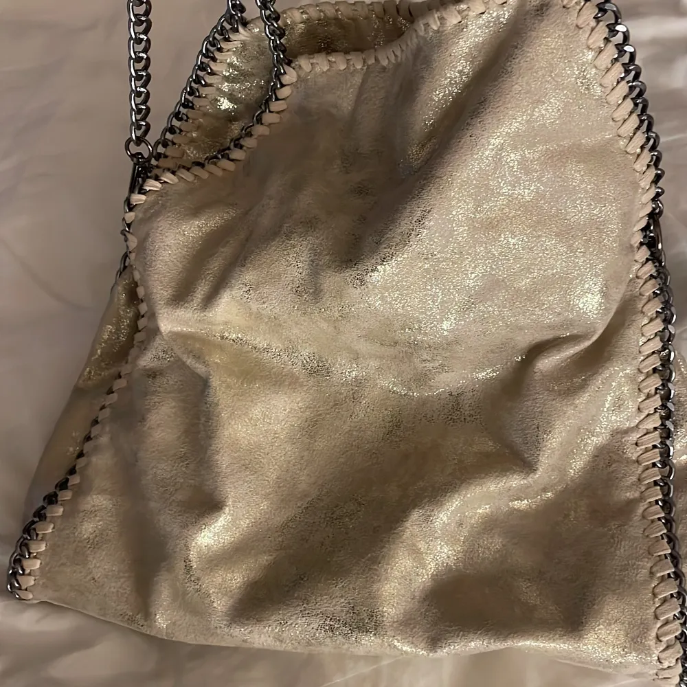 Stella liknande väska i fint skick! Väskan är i en fin champagne färg med skimmer. Köpte i januari och använt väskan några gånger sen dess! ❤️‍🔥Säljer för 290kr, köparen står för frakten!. Väskor.