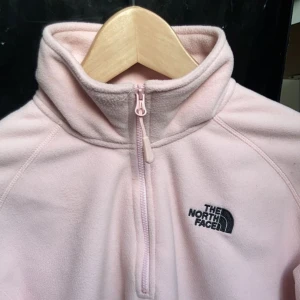 North face sweater  - En rosa north face sweater av fleece tyg som är väldigt varm, har använt en gång men kommer inte mer till användning då jag inte gillar längden på den, skulle gärna vela ha den lite längre. OBS: Frakten kostar 45kr eftersom att jag äger paketering etc :) 