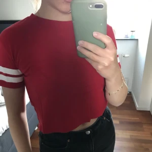 T-shirt  - Röd t-shirt i storlek XS, men passar mig som är S, från H&M. Den är lite croppad, vilket syns på bilden. Är i väldigt bra skick.