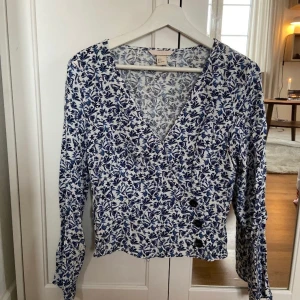 Blus, omlott  - Nyskick omlott- blus. Skönt material med fint blommönster. Storlek 38 , liten i storlek. 