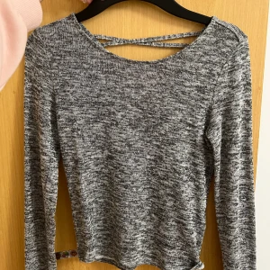 Grå överdel - En tunn långärmad grå topp med snöras rygg 