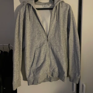 GRÅ WEEKDAY ZIP-HOODIE - Säljer min zip-hoodie från weekday Varan är i superfint skick, nyskick. Endast tvättad en gång. Säljer pga inte min stil.