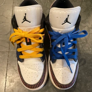 Air Jordan Low MMD 37,5 - Air Jordans som är använda sparsamt. Har små tecken på slitage men är överlag fräscha. Ena skon har gul sula med blått snöre, den andra tvärtom. Swoshen är neonorange på bägge.  Skon är vit, svart, neonorange, gul och ljusblå. Storlek 37,5