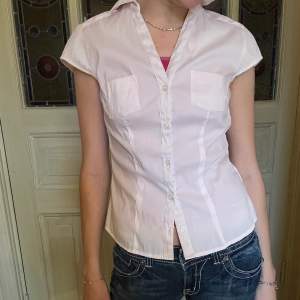 Vintage kortärmad skjorta, väldigt ljusrosa nästan vit. Snyggt figursydd i midjan 