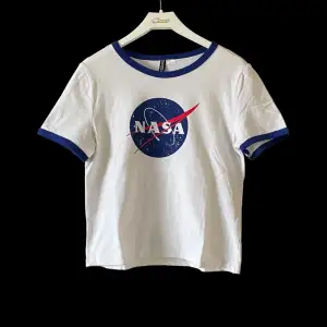 Fin vit och blå tröja med NASA tryck på. Skön och stretchig, använd ett par gånger men i väldigt bra skick.  Köparen står för frakten