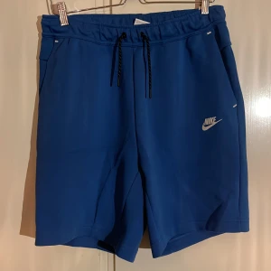 Nike Tech Fleece Shorts - Den populära Nike Tech Fleece modellen i shorts har jag nu till försäljning. ALDRIG använda! Färgen är blå. Orginalpris är 749kr mitt pris är 400kr. 😁